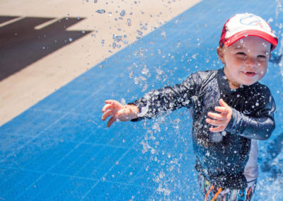 young boy playing in water at the splash pad