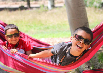 day camp boy campers hang out in a hammock with their sunglasses on