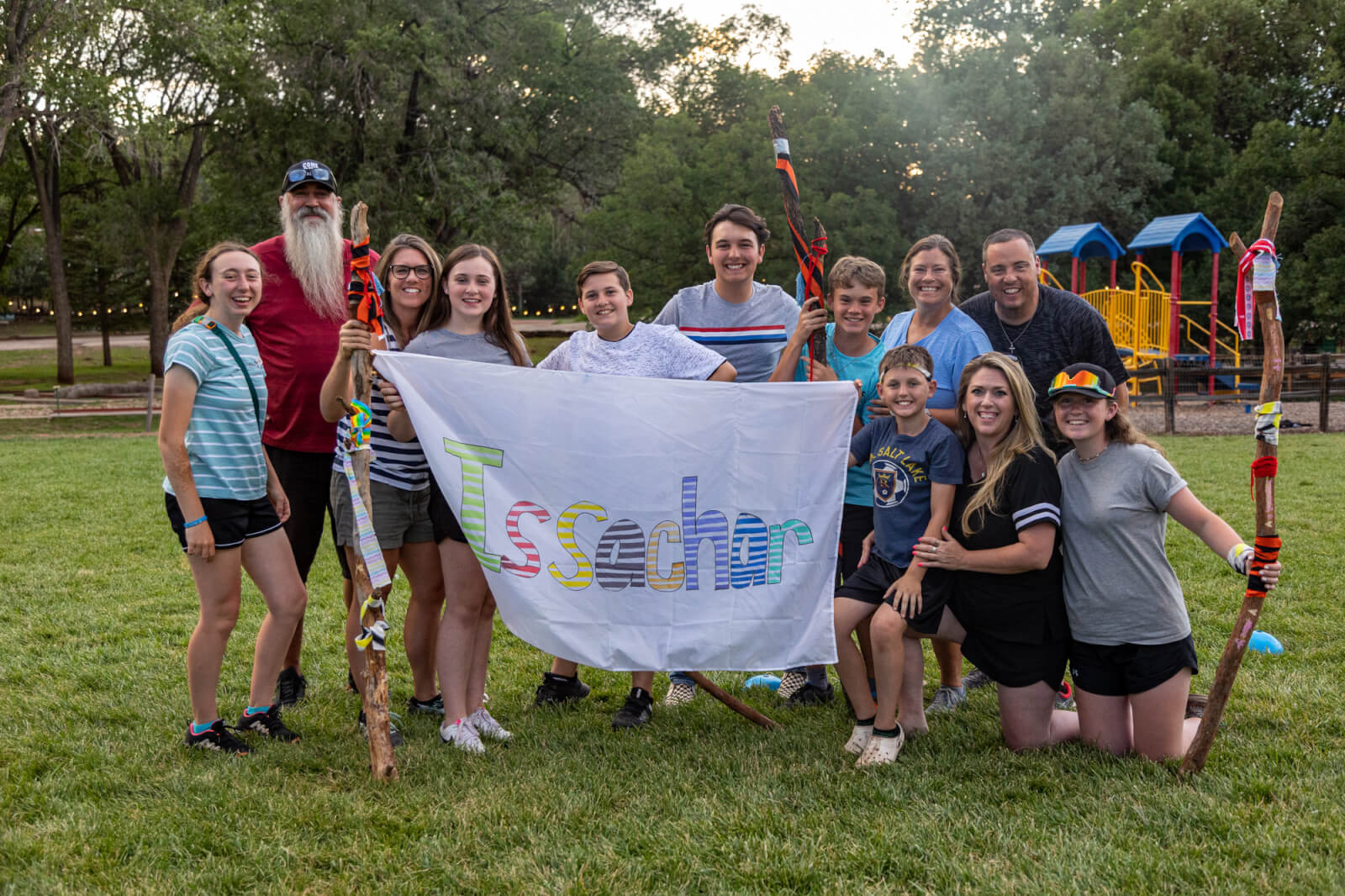 family holding up a homemade banner smiling