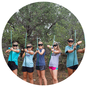 line of girls with bows and arrows taking aim