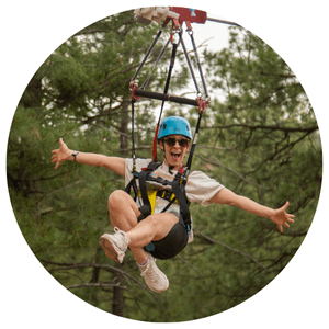 lady with arms out smiling riding a zipline