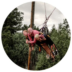 3 family members in a harness on a large swing